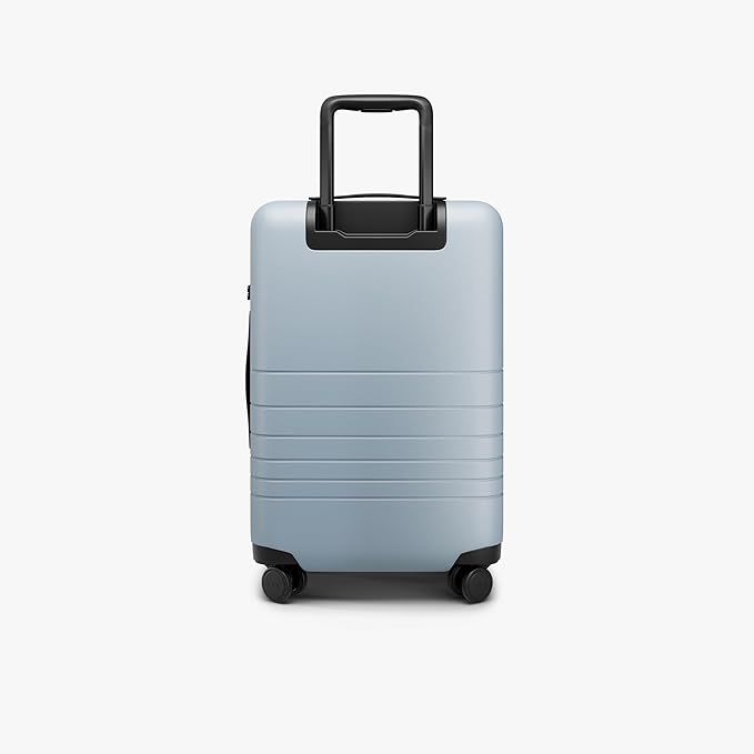 Monos Carry-On Pro Plus Luggage (23"), Hardside Spinner Suitcase with TSA Lock & Front Pocket, Airline Approved, Blue Haze